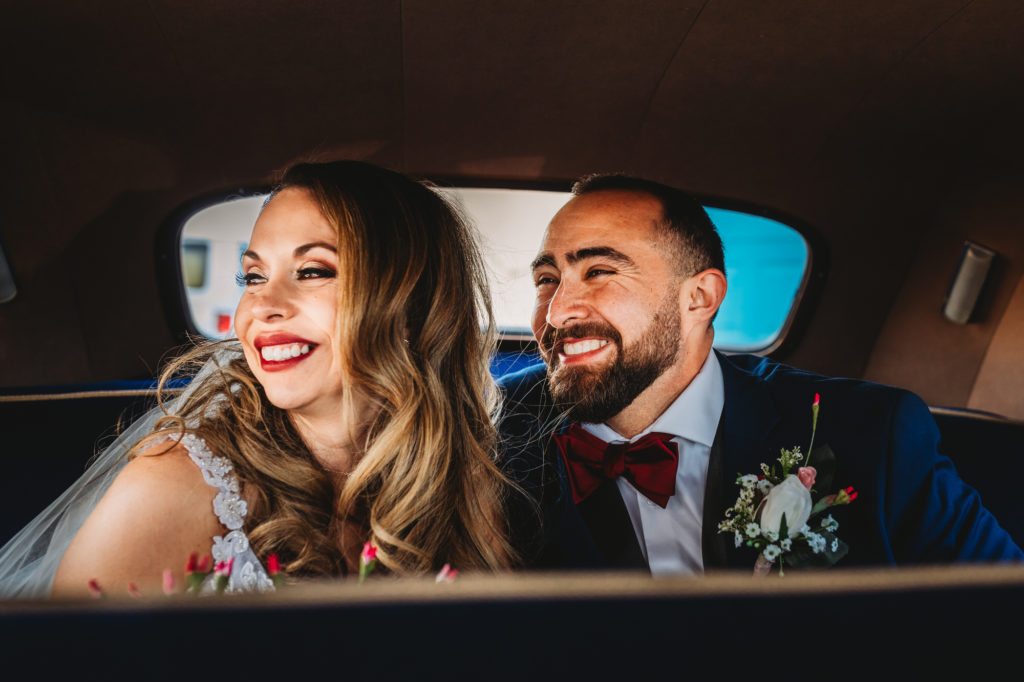 Bride and Groom laughing in vintage car in Rhode Island