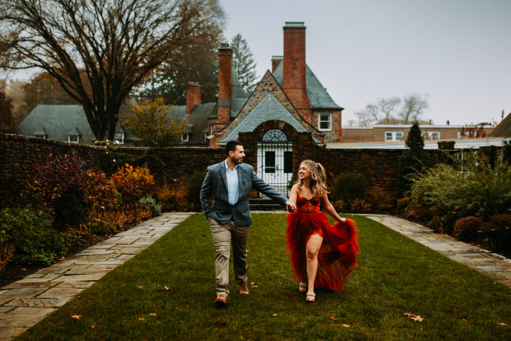 A couple walks in the garden at their engagement session at Shepherd's Run in Rhode Island