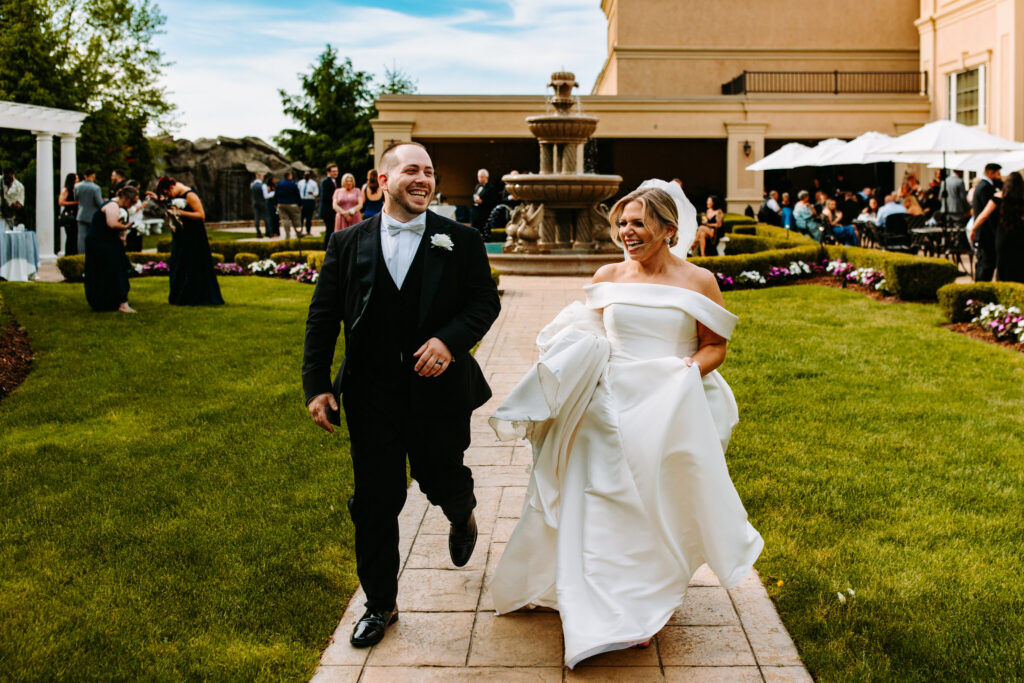 Bride and groom run joyfully at their wedding at Aria Banquets in Connecticut