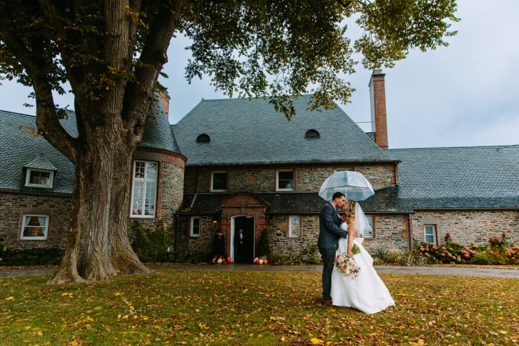 A bride and groom kiss on a rainy wedding day at Shepherd's Run in Rhode Island