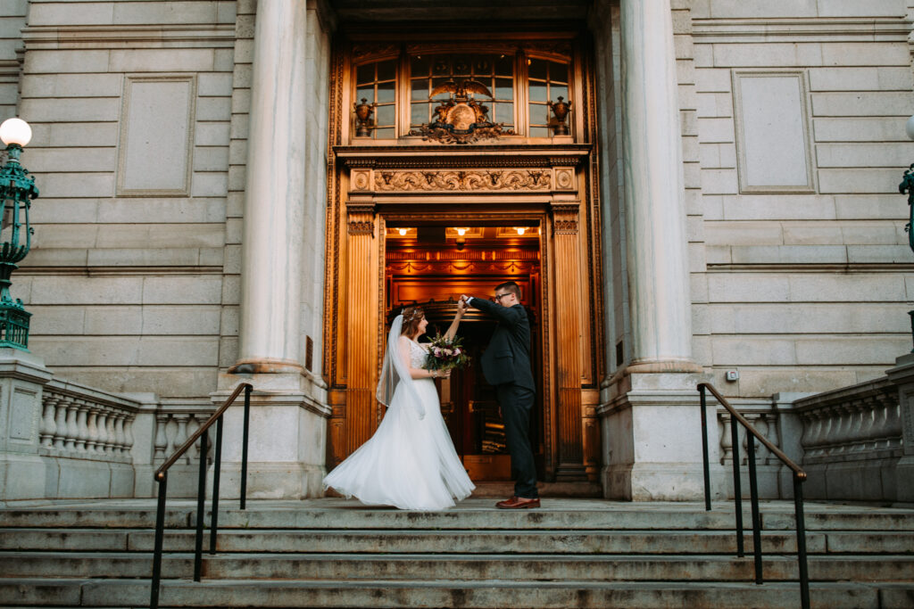 A bride and groom dance at the entrance of Hartford City Hall at their elopement