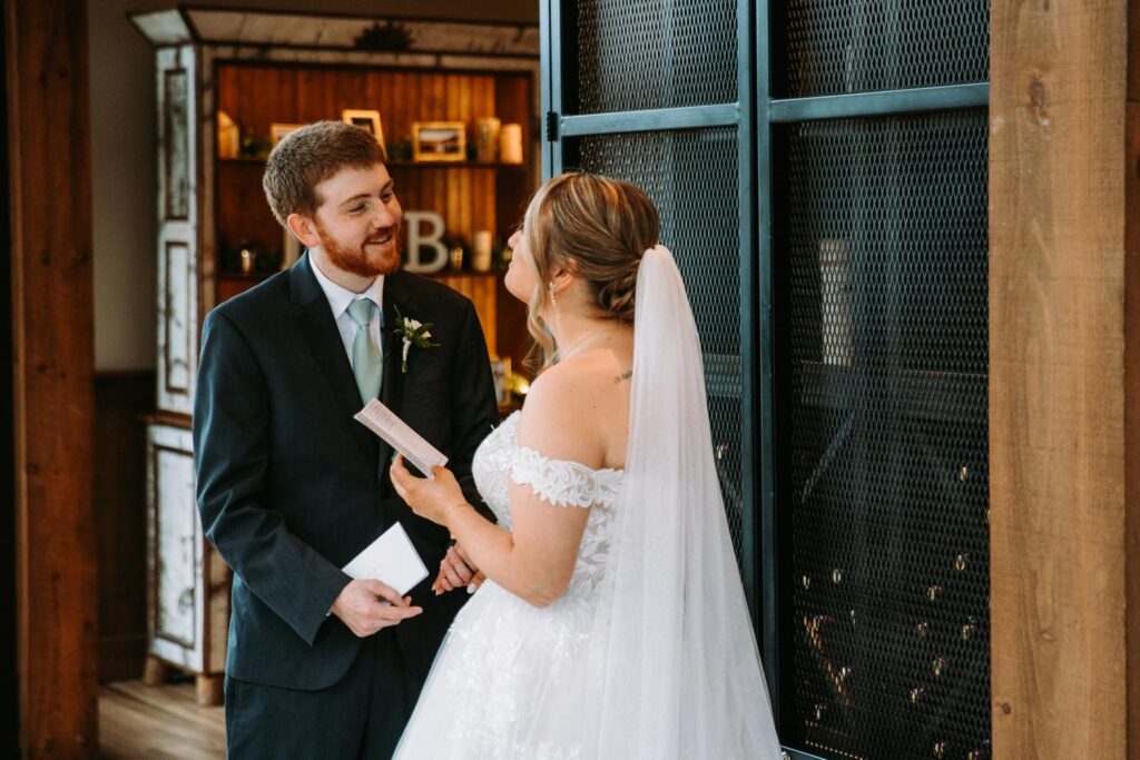 Bride and groom standing close together during private vow exchange in intimate indoor space

