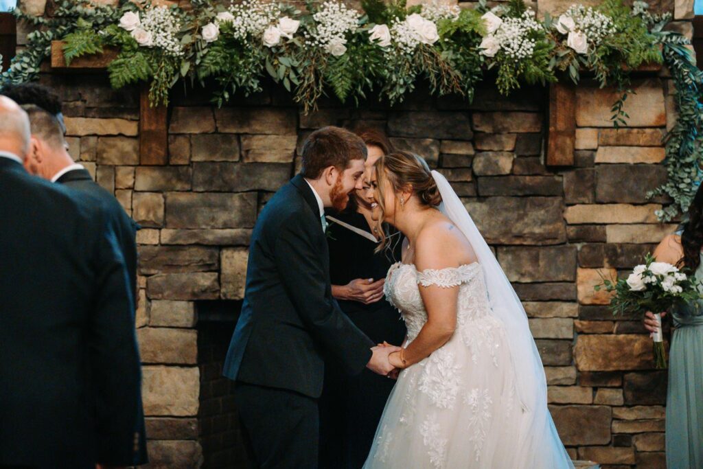 Bride and groom beaming as they’re announced as officially married, surrounded by cheering loved ones
