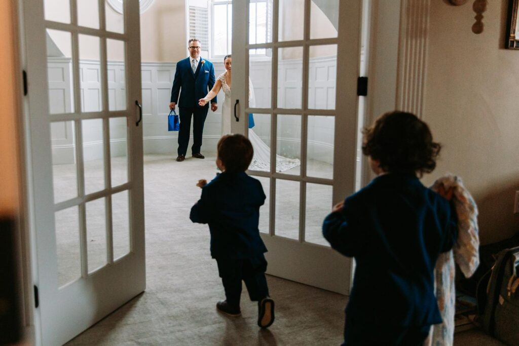 Dayna and Aaron’s toddlers running through French doors to see their dad for the first look.