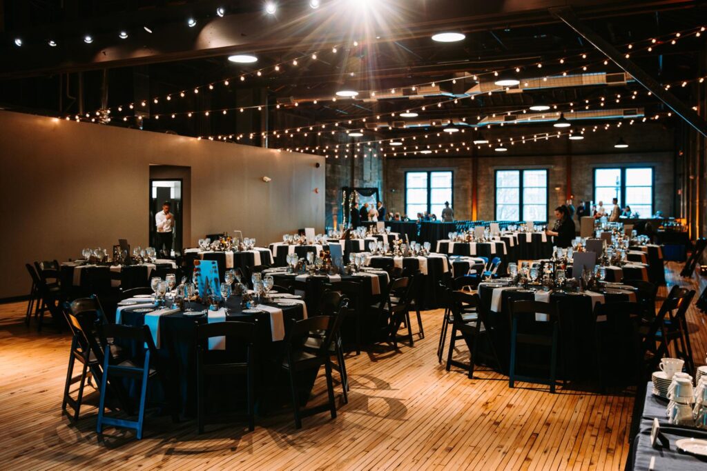 Wide view of the Olio reception space with dark wood floors and string lights.