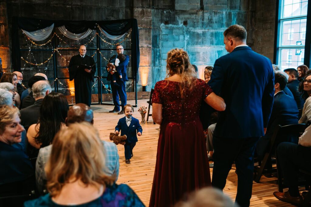 A wedding guest walks an older relative down the aisle before the ceremony begins.