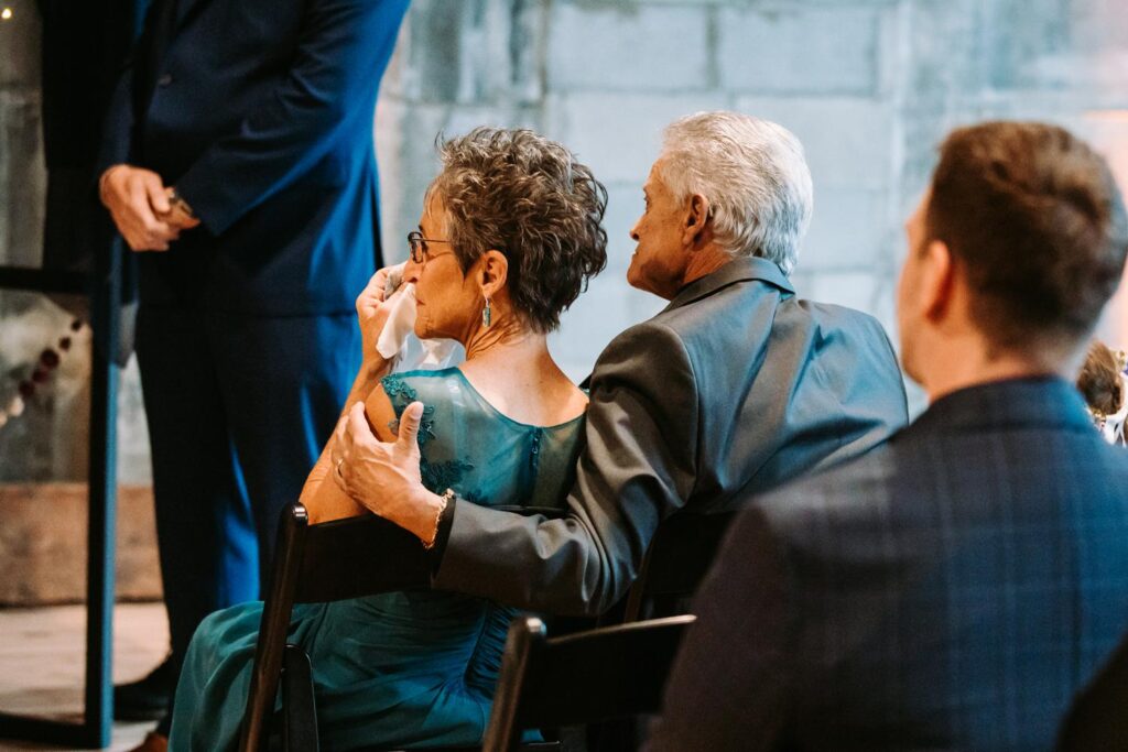 Guests wiping away tears while watching the couple exchange vows.