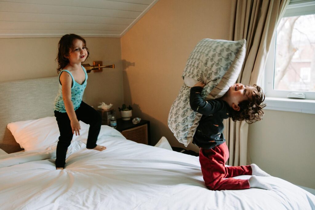 One of the couple’s toddlers jumping on the bed in joyful chaos before the ceremony.