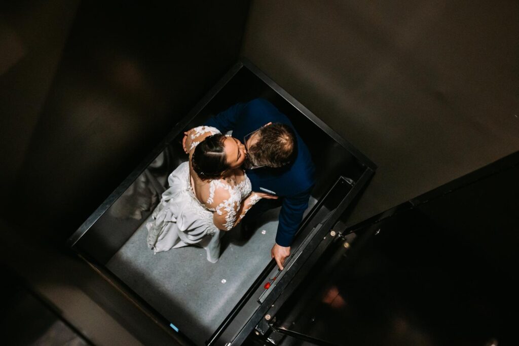 Bride and groom sharing a kiss in the elevator at the end of the night
