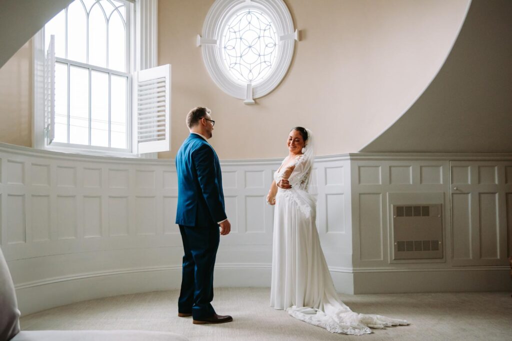 Bride adjusting her veil, soaking in a quiet moment before the ceremony.