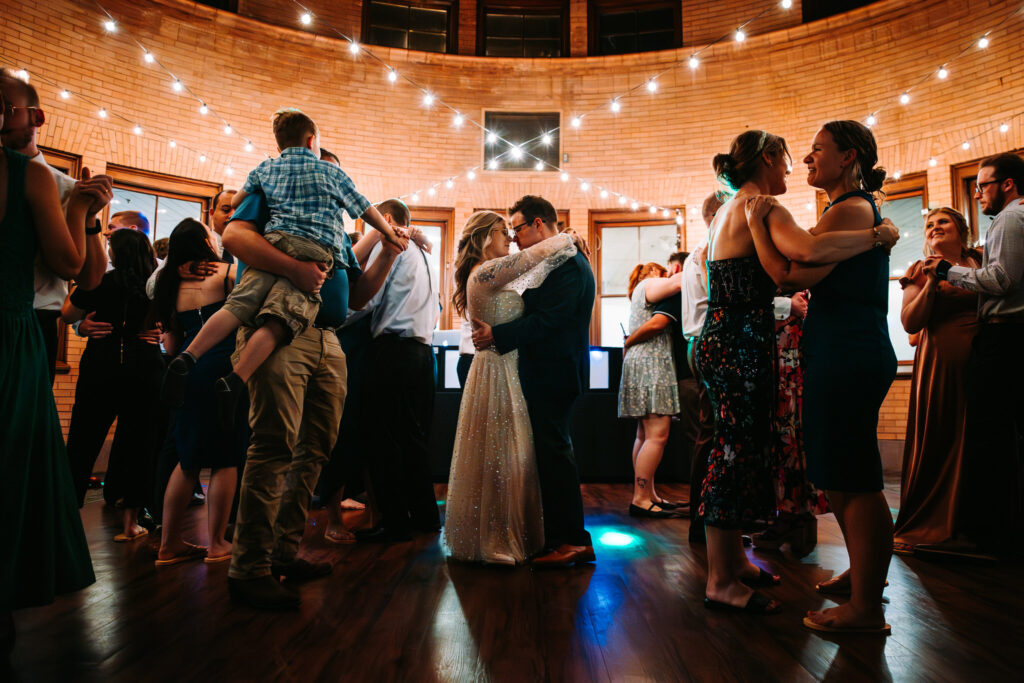 Couple shares an intimate dance together in the middle of a packed dance floor at Union Station Banquets