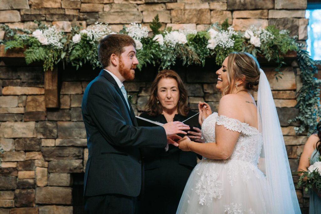 Bride and groom holding hands and sharing emotional vows during their ceremony at Birch Wood Vineyards

