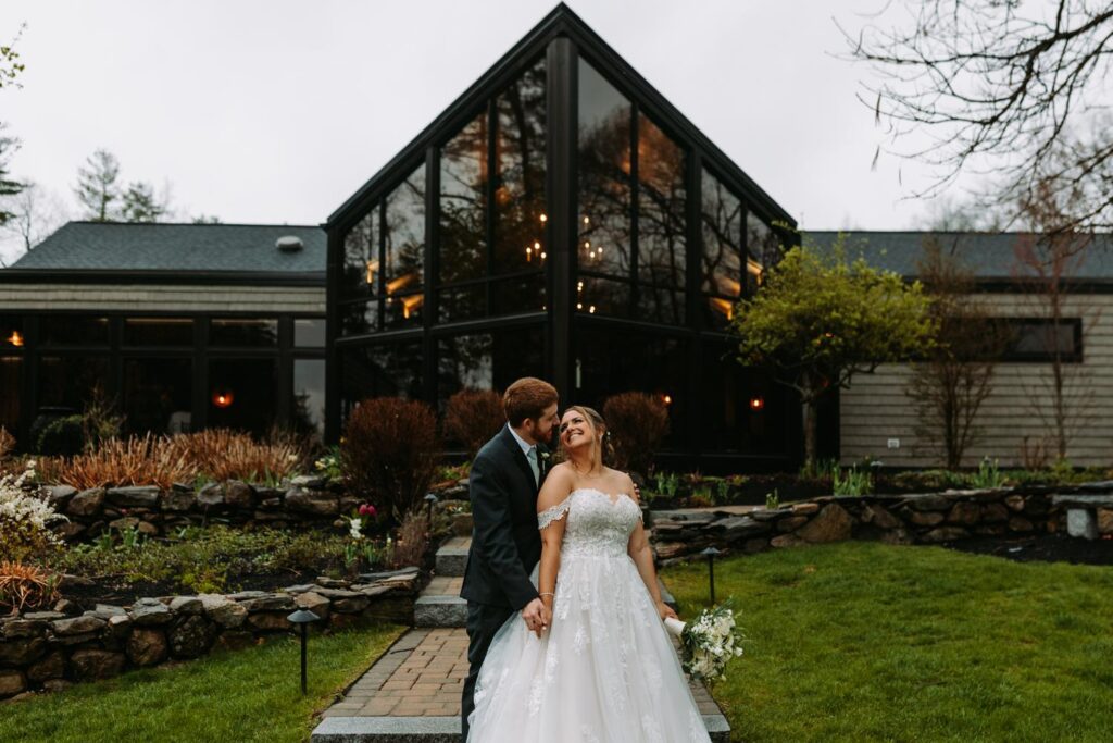 Bride and groom posing in front of the iconic glass barn doors at Birch Wood Vineyards