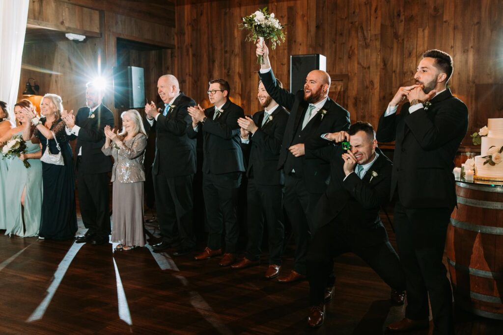 Wedding party cheering as the newlyweds make a grand entrance onto the dance floor