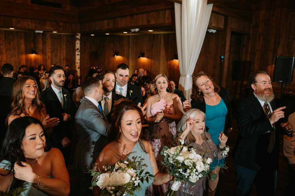 Guests reacting joyfully and hyping up the couple during speeches or intros