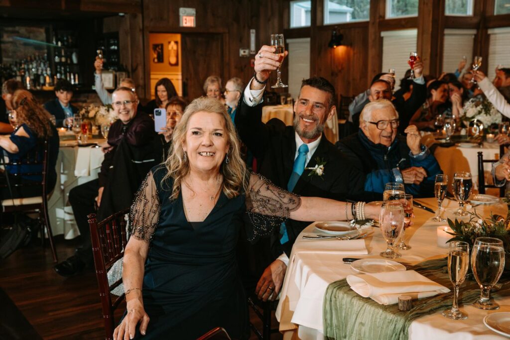 Wedding guests raising glasses in a joyful toast during the reception