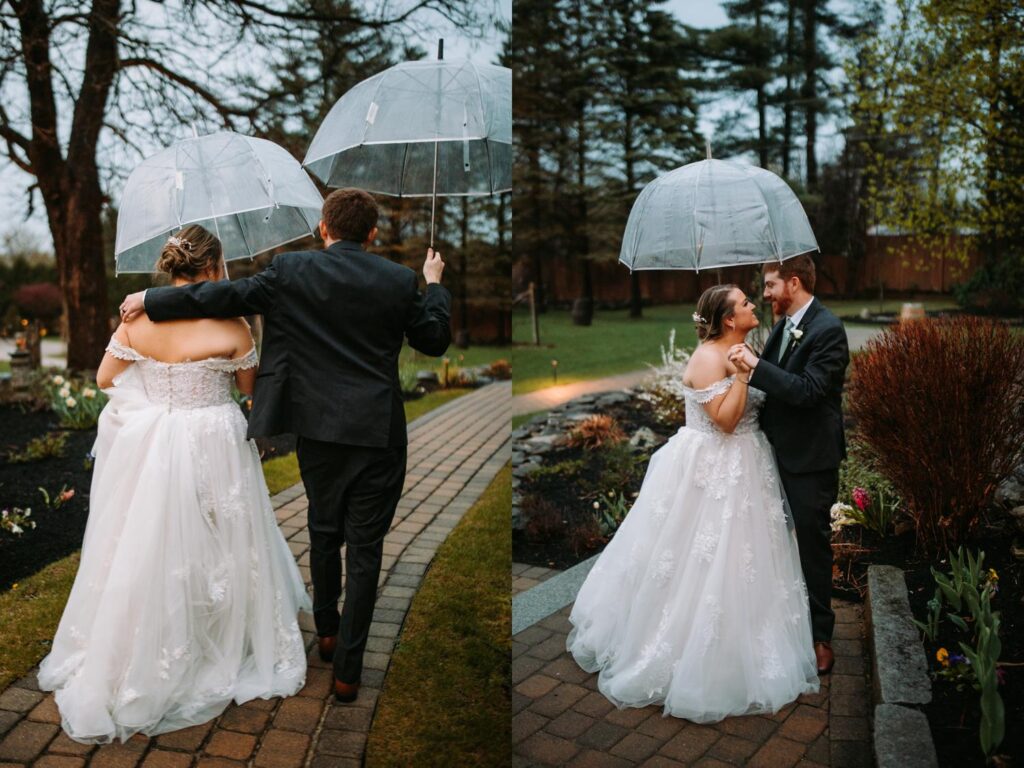 Bride and groom walking hand-in-hand under a clear umbrella on a rainy evening

