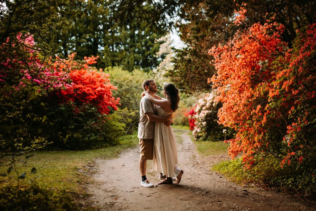 Couple sharing a slow dance surrounded by fiery orange azalea bushes.