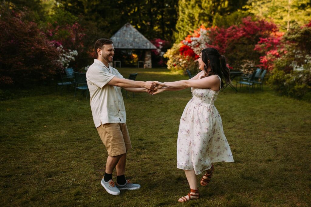 Playful moment as the couple dances among spring blooms in the golden-hour light.