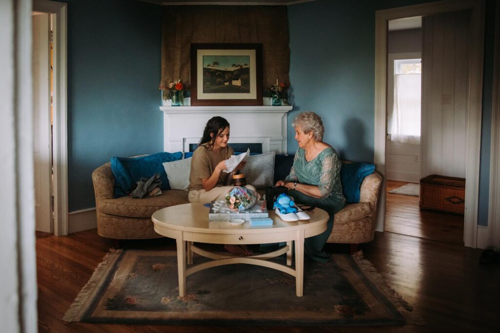 Bride and grandmother share a quiet moment in the farmhouse living room.