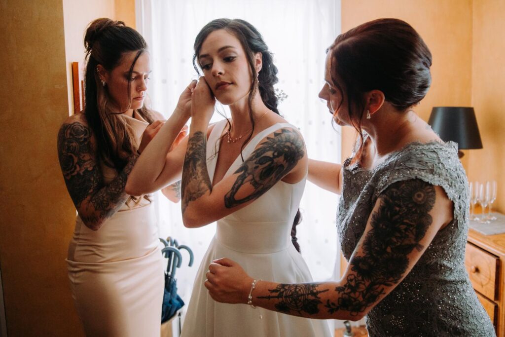 Bridesmaid and mom offer support in warm farmhouse lighting.