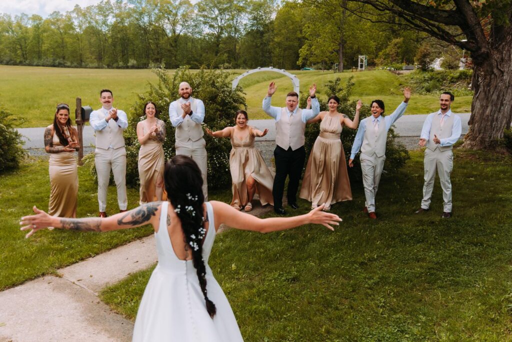 Bride walking toward her wedding party on the lawn at Bluebird Farm.