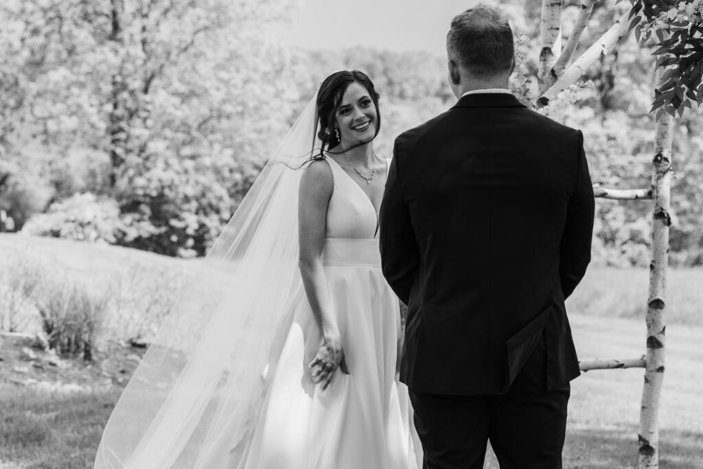 First look moment between bride and groom surrounded by spring greenery in the Catskills.