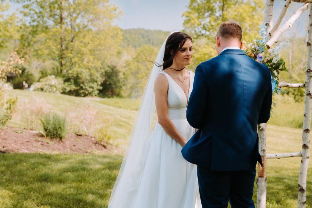 Bride and groom sharing a laugh during their first look in upstate New York.