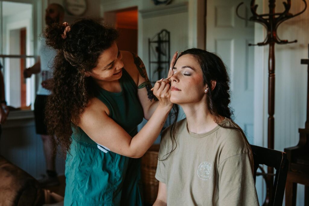 Bride having makeup applied while smiling in a relaxed setting