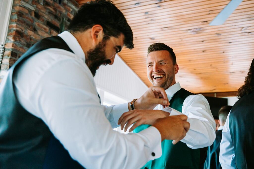 Groomsmen laughing and getting ready inside the Bluebird Farmhouse.