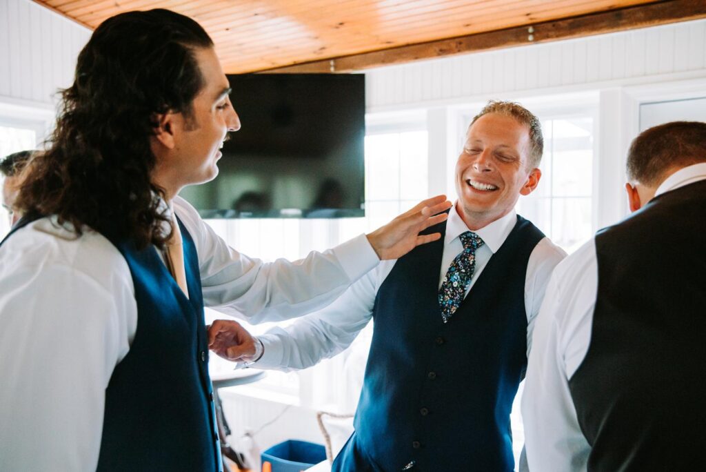 Groom and groomsman share a light moment before the wedding ceremony