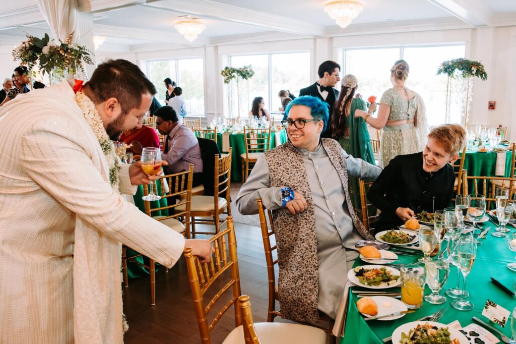 Lively table conversation among guests during Indian wedding reception at Grandview Mendon Massachusetts