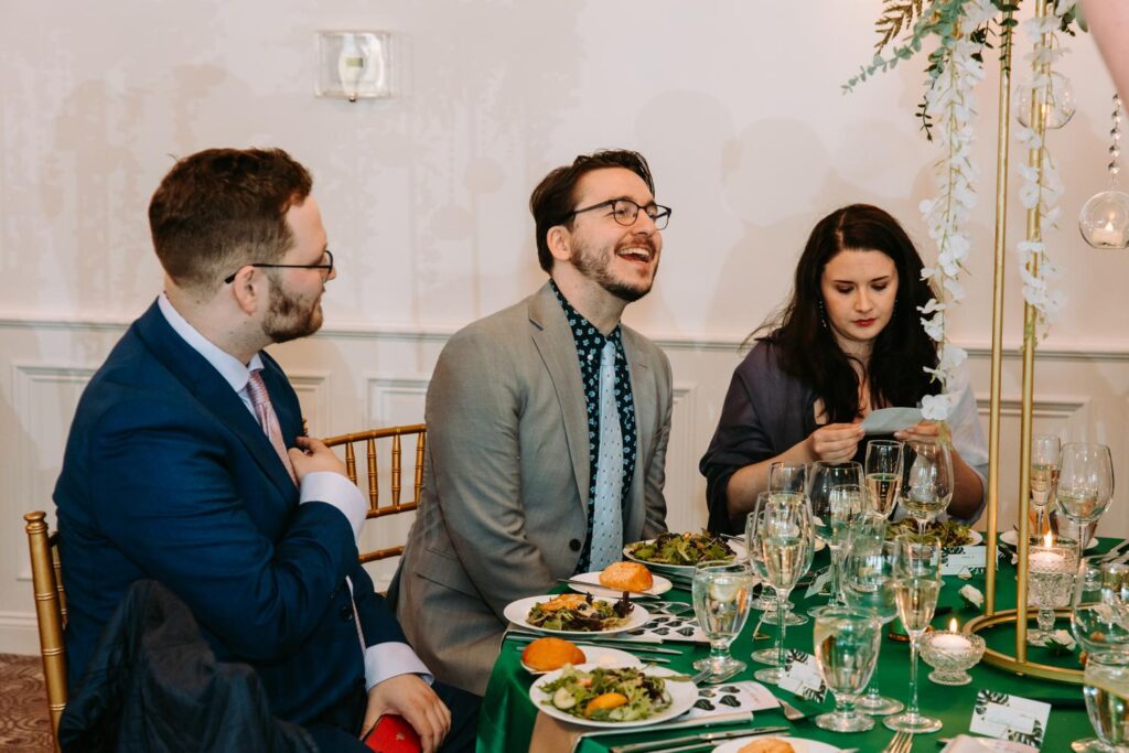 Guests laughing at dinner table during Indian wedding reception at Grandview Mendon Massachusetts.
