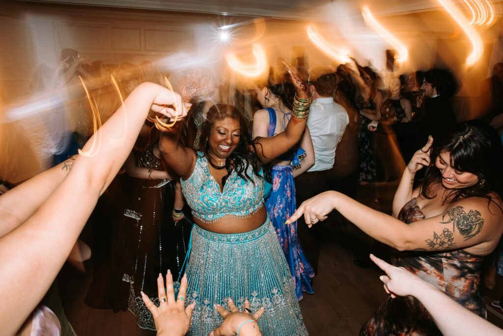 Bride and groom celebrating on packed dance floor during Indian wedding reception at Grandview Mendon Massachusetts
