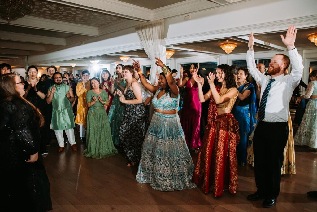 Group of friends raising arms on dance floor at Grandview Mendon Massachusetts Indian wedding