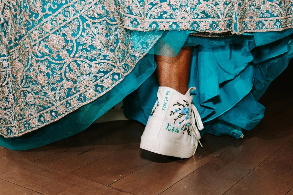 Bride’s sneakers peeking out under lehenga during Indian wedding reception at Grandview Mendon Massachusetts
