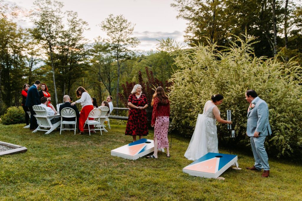 Guests playing cornhole on the lawn at The Barn on Gobeille Farm wedding in Sharon Vermont