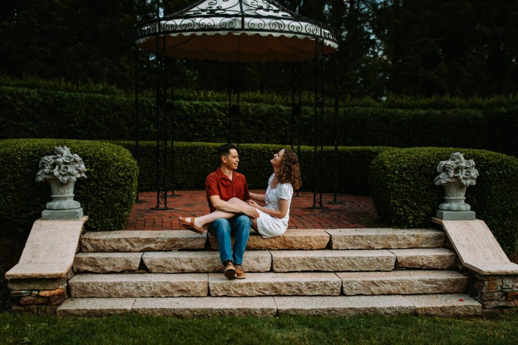 Couple sits on the steps of the English Garden at Wickham Park in Manchester