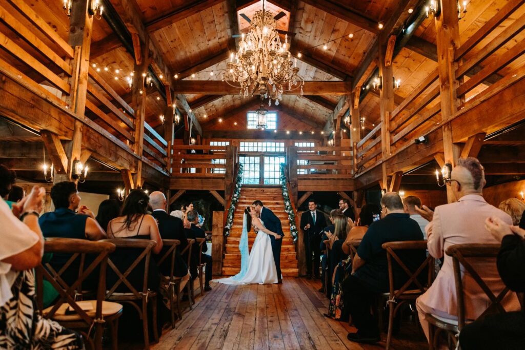 First kiss during wedding ceremony in The Barn at Red Lion Inn in Cohasset, Massachusetts