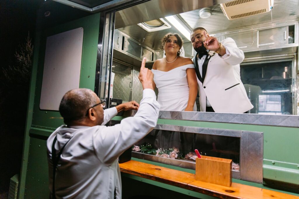 A bride and groom have a funny moment in the Walnut Hill Creamery ice cream truck