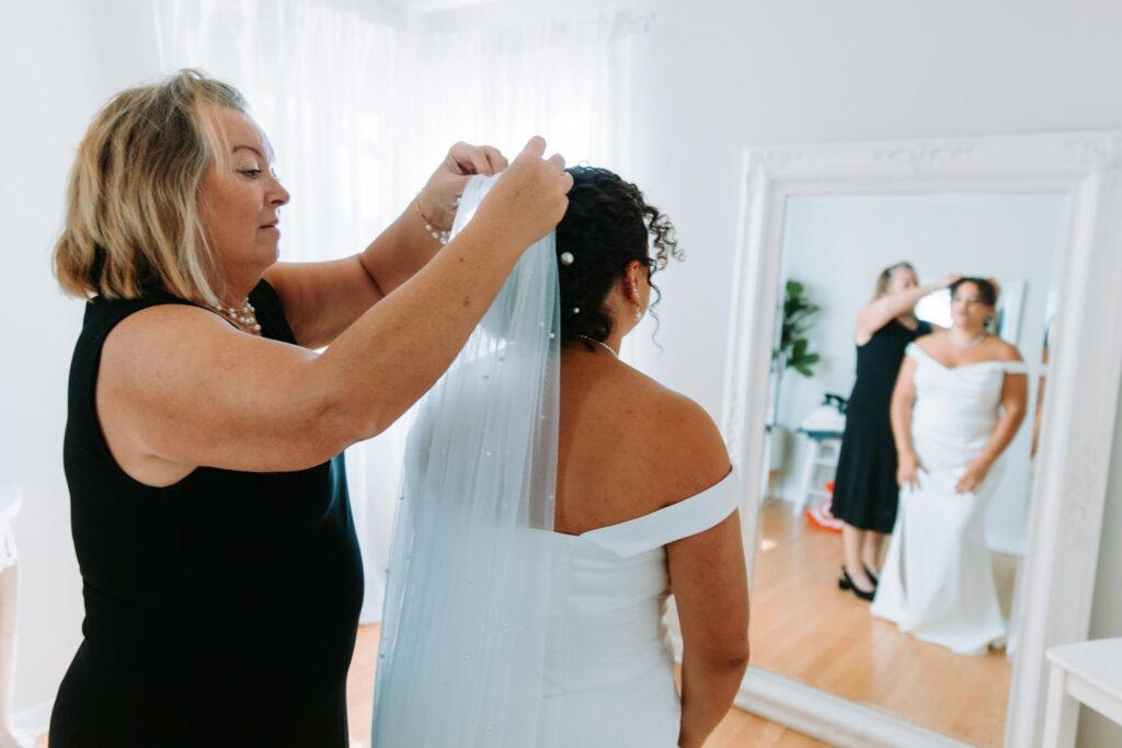 A mom puts a veil on her daughter on her wedding day at The Hops Company in Connecticut