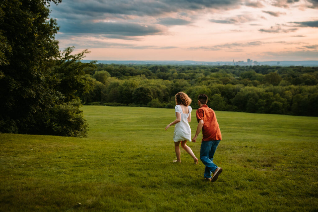 Couple runs through hilltop field at Wickham Park in Manchester Connecticut