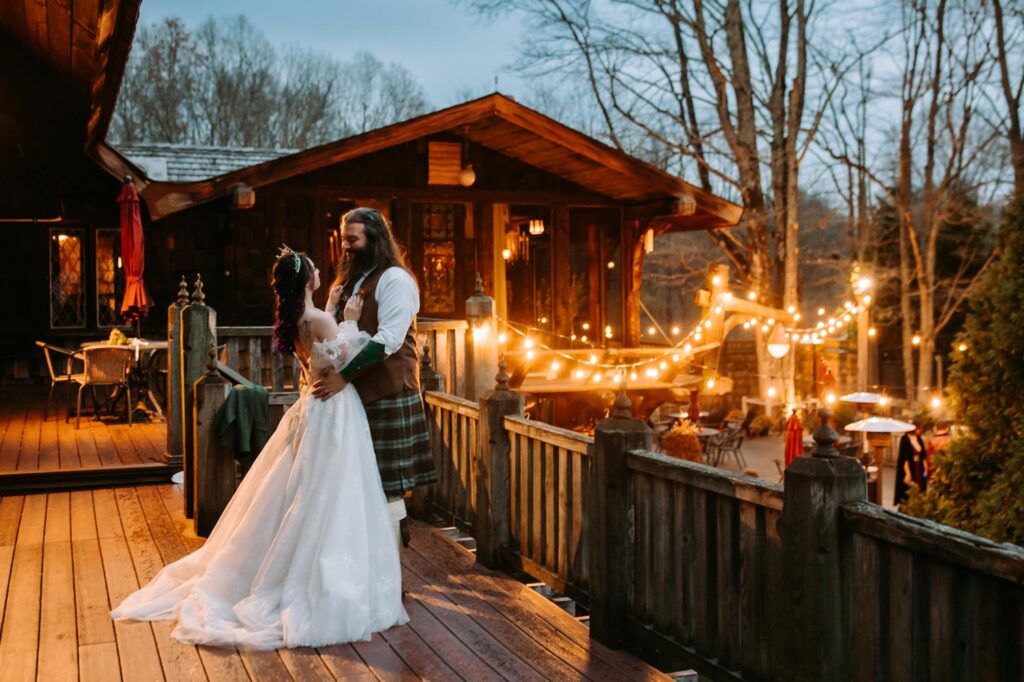 Bride and groom in medieval themed outfits stand on the patio at Bill Miller's Castle