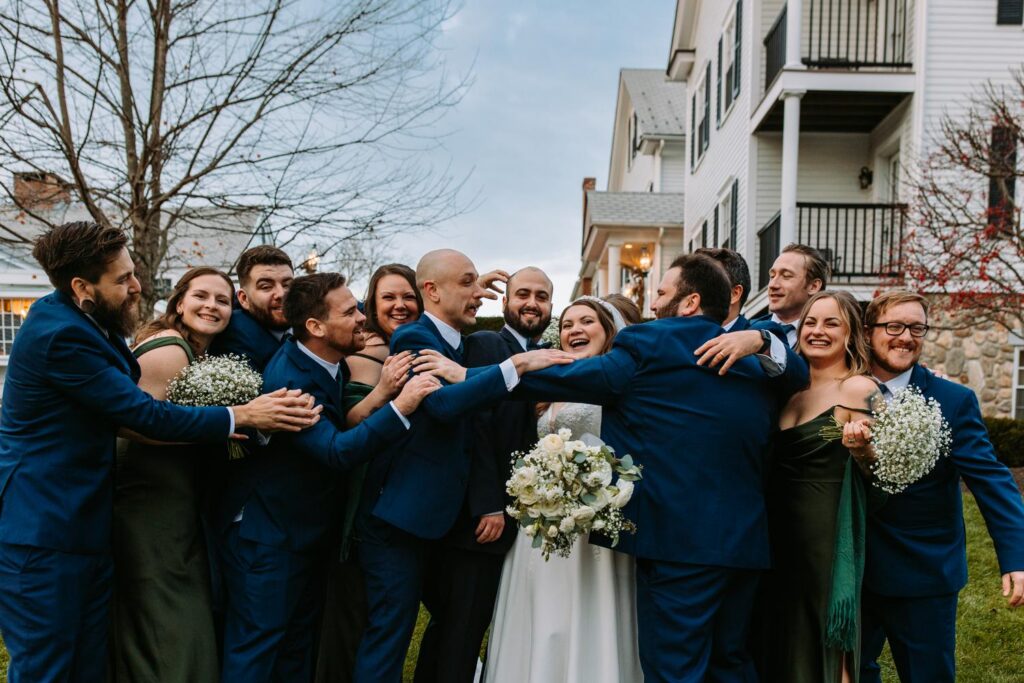 Wedding party gathered closely together laughing and celebrating after the ceremony