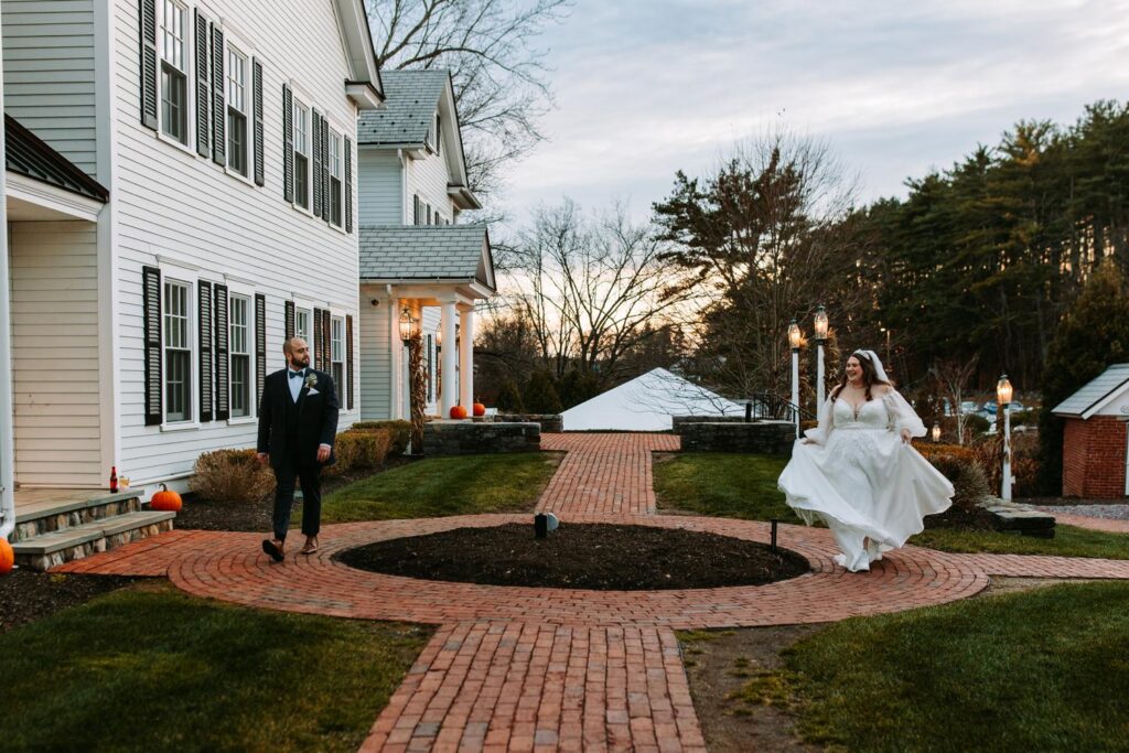 Bride and groom walking together down a brick path after the ceremony with guests behind them