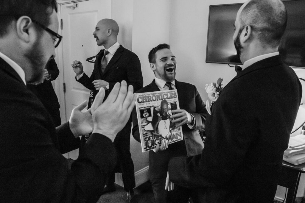 Black and white groomsmen reacting to vinyl record gifts at The Publick House wedding in Sturbridge Massachusetts