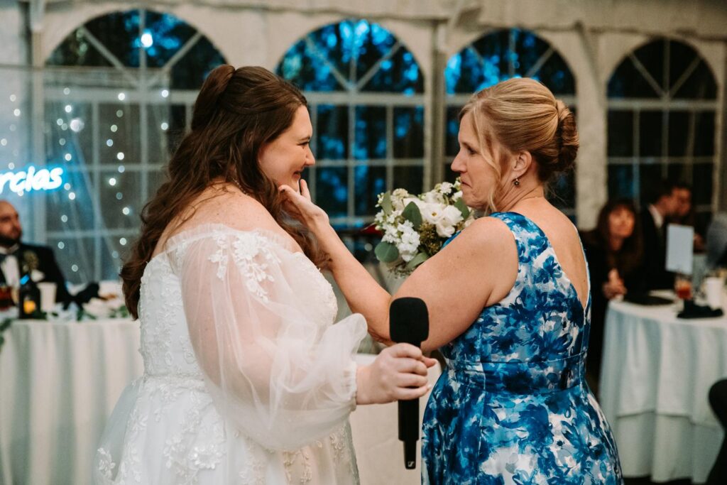 Bride hugging a guest in a blue dress during the reception