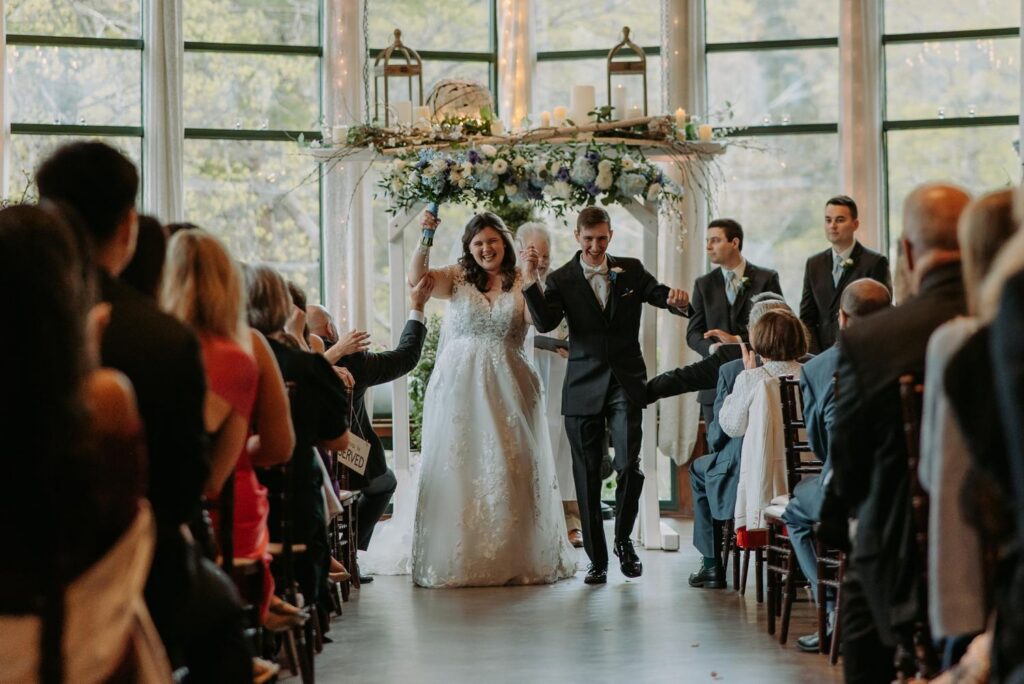 Bride walking down the aisle with groom, guests standing, Elizabeth Park wedding West Hartford CT