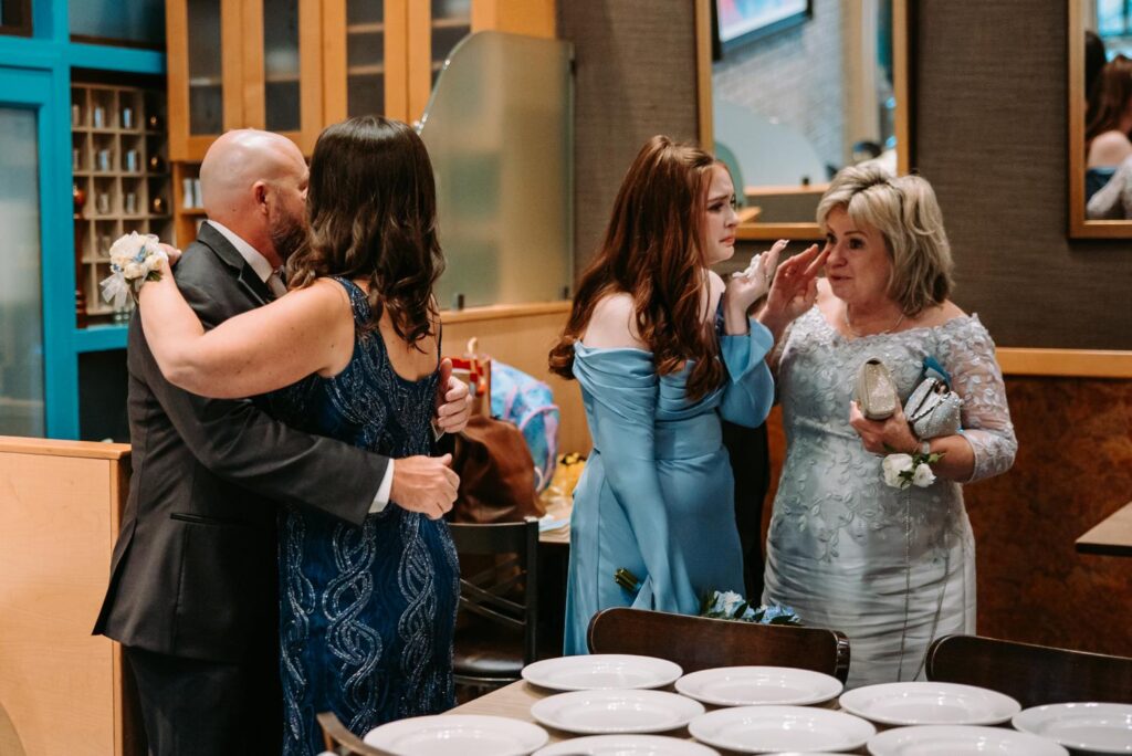 Family members hugging at cocktail hour, Pond House Cafe wedding