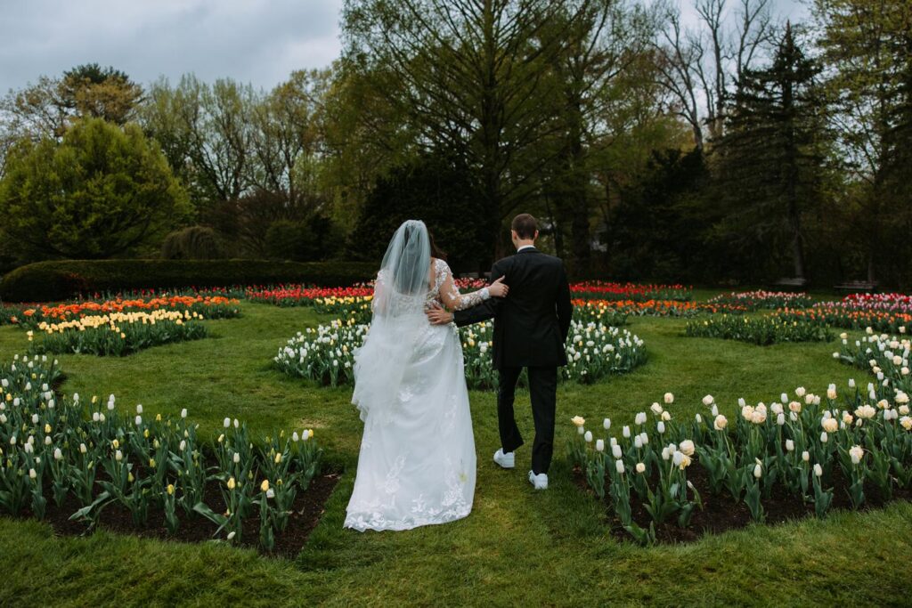 Couple standing in white and yellow tulip beds at Elizabeth Park West Hartford Connecticut